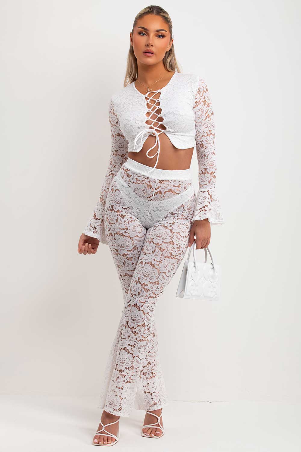 white lace skinny flare trousers and bell sleeve lace up front going out crop top summer holiday festival rave outfit