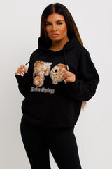 womens black oversized hoodie with teddy bear graphics and palm springs slogan