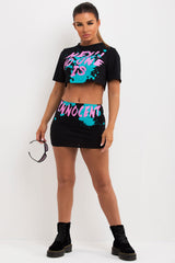 festival outfit crop t shirt and mini bodycon skirt with no one is innocent slogan