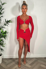 red going out summer holiday skirt and long sleeve crop top co ord with gold buckle 
