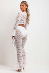 white lace skinny flare trousers and long flare sleeve lace up front crop top two piece going out co ord set summer festival outfit